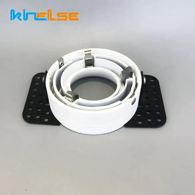 White coiled cable clamp with metallic silver clips and black perforated mounting plates for decorbites led round recessed ceiling fixture