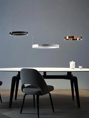 Modern minimalist decorbites led round ring chandelier in black white and copper hangs above a sleek dining table