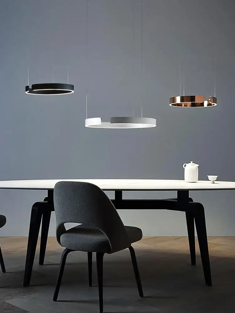 Modern minimalist decorbites led round ring chandelier in black white and copper hangs above a sleek dining table