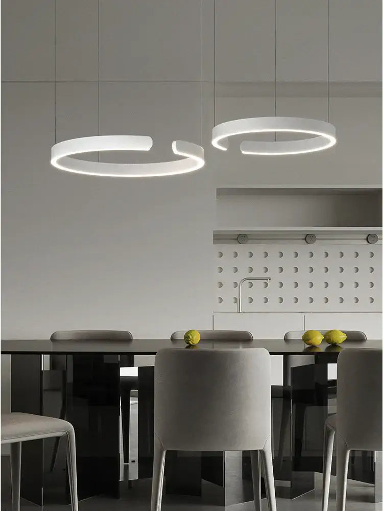 Modern white circular decorbites led round ring chandelier with minimalist design hanging above dining table