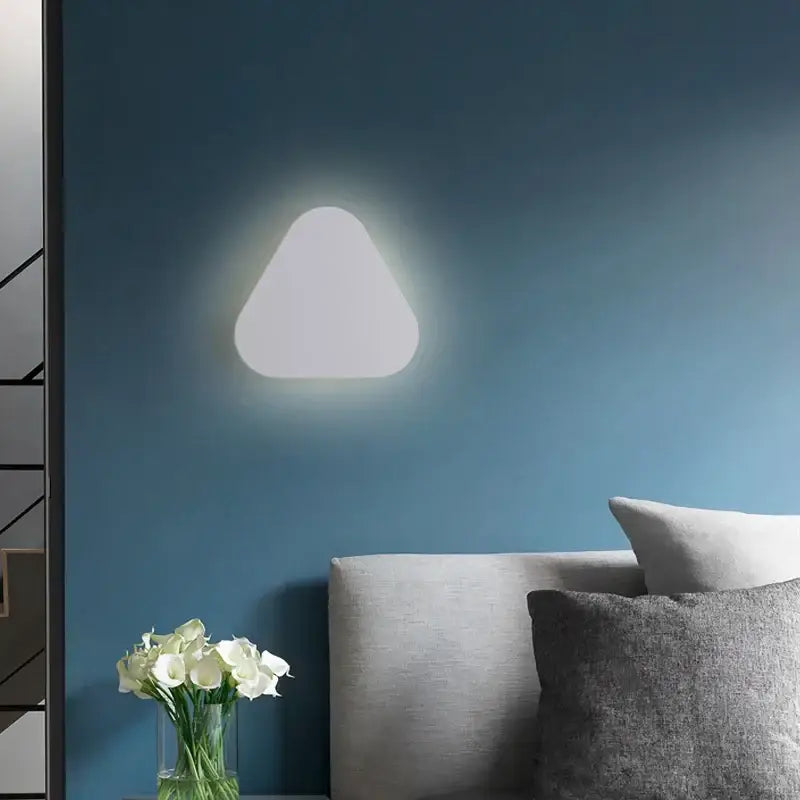 A sleek triangular decorbites led round touch wall lamp emitting soft white glow for bedroom and aisle decor