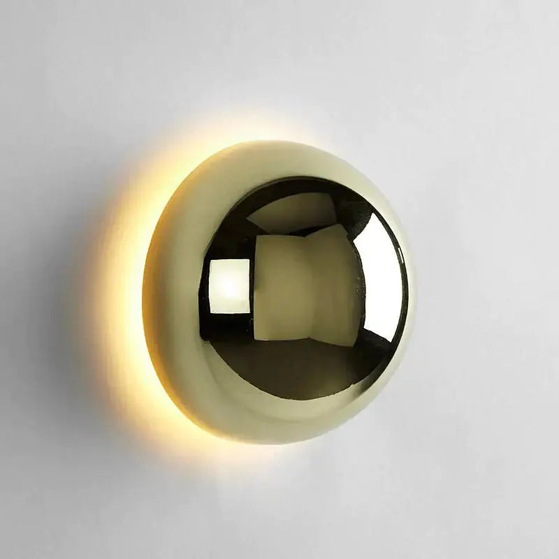 A sleek polished gold DecorBites LED Scandinavian sconce wall lamp with illuminated halo for modern medieval decor