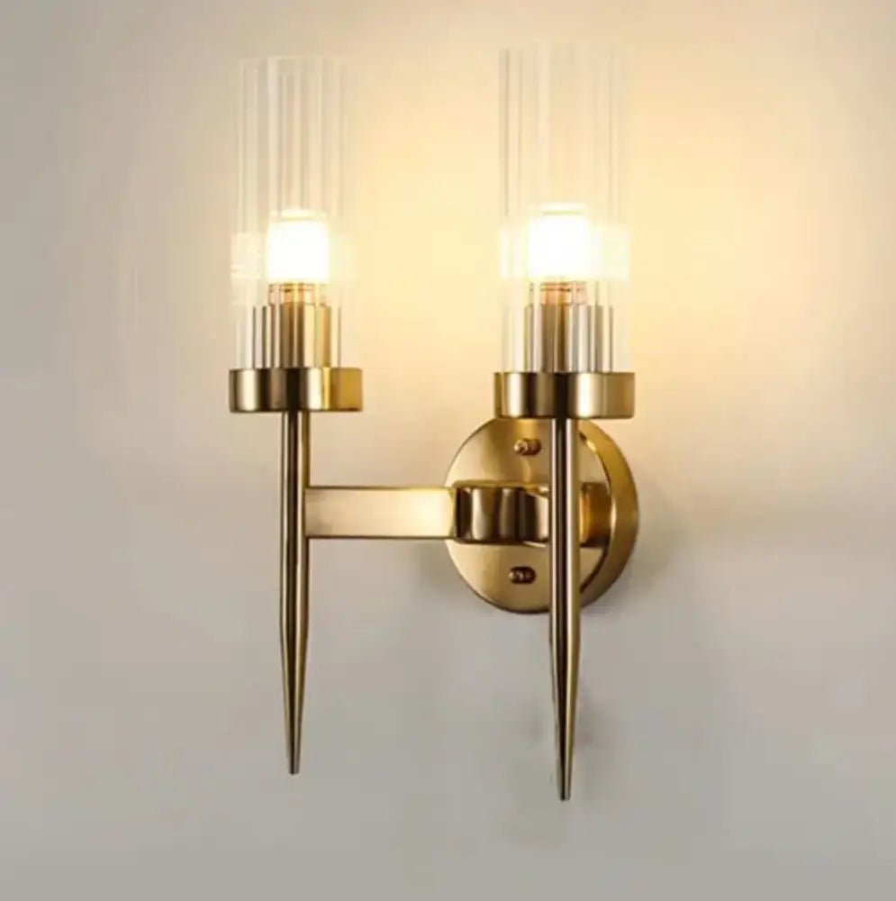Brass-finished decorbites led sconce with two clear glass candle-style shades for bedroom and home lighting