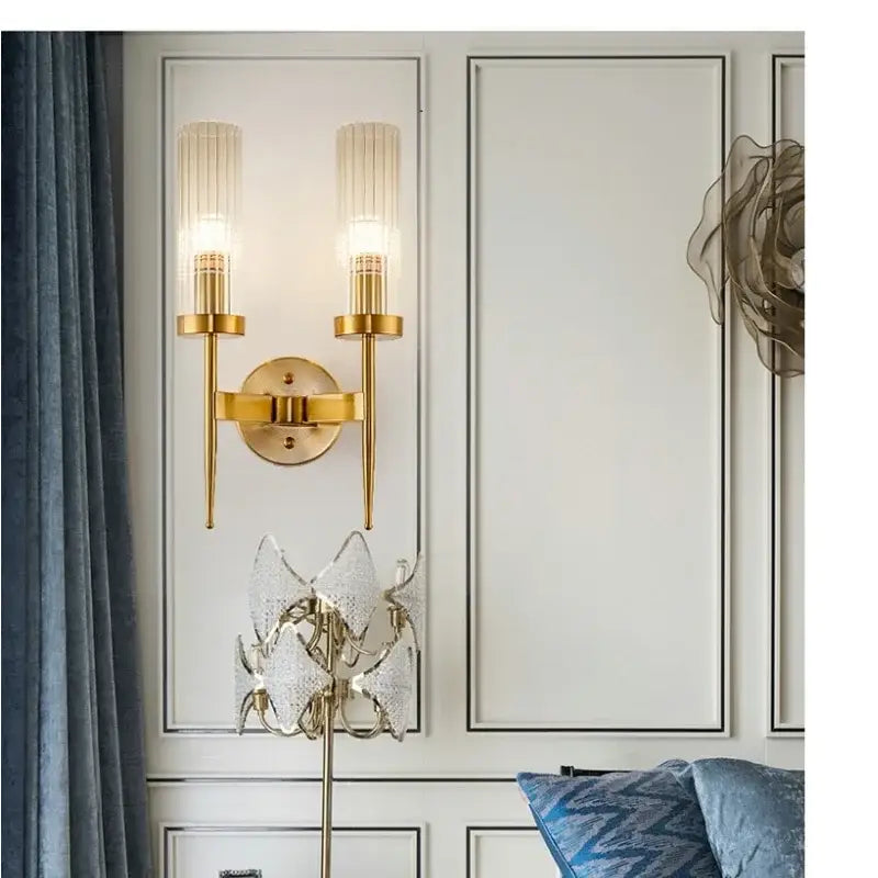 Gold-toned metal decorbites led sconce light with two vertical ribbed glass shades for bedroom and home use