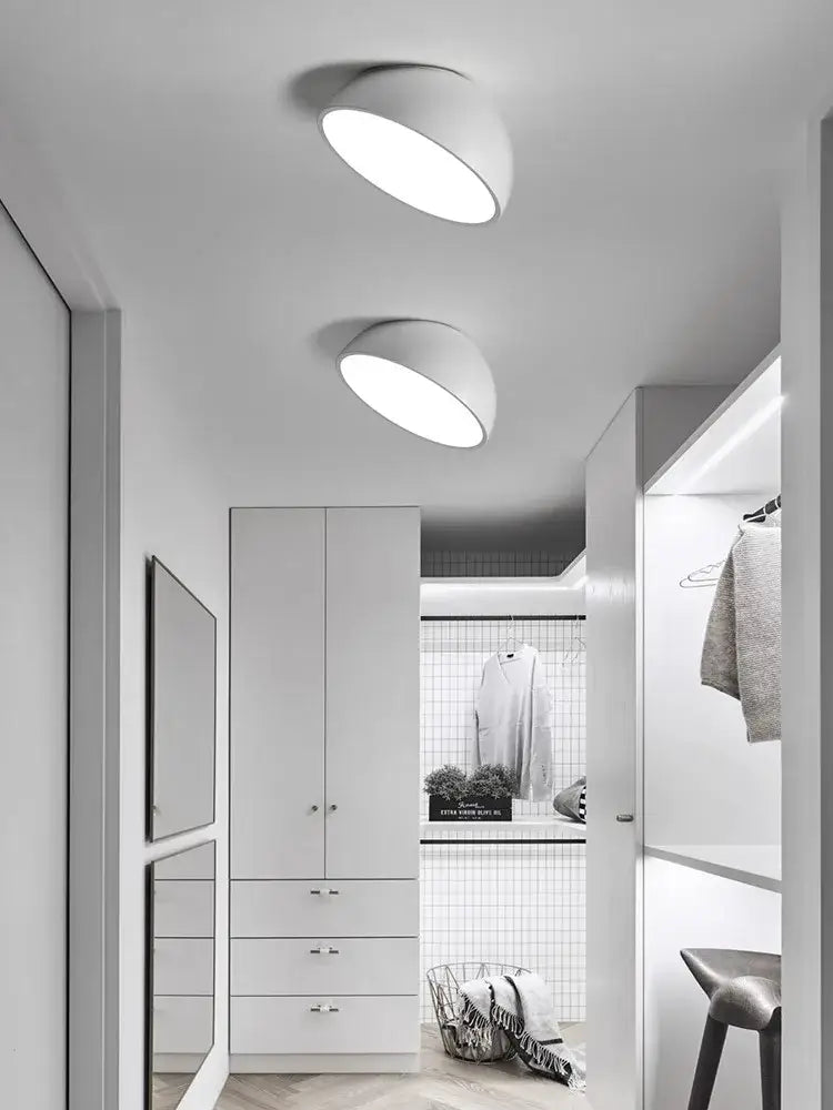 Two sleek white decorbites led semicircular ceiling lights illuminate a hallway with modern minimalist design