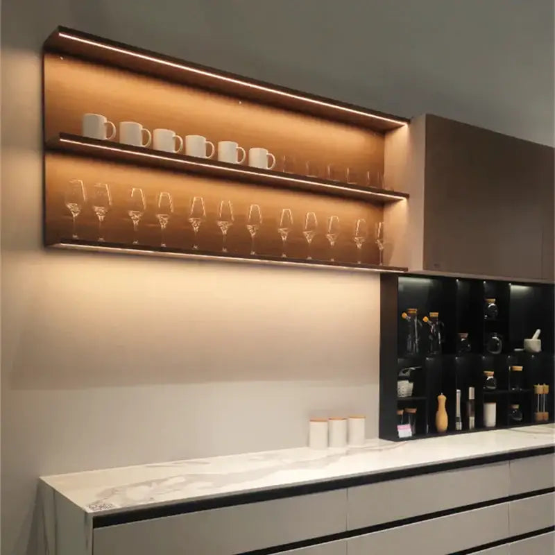 Modern wooden floating shelves with integrated led shelf light displaying white ceramic mugs and clear wine glasses