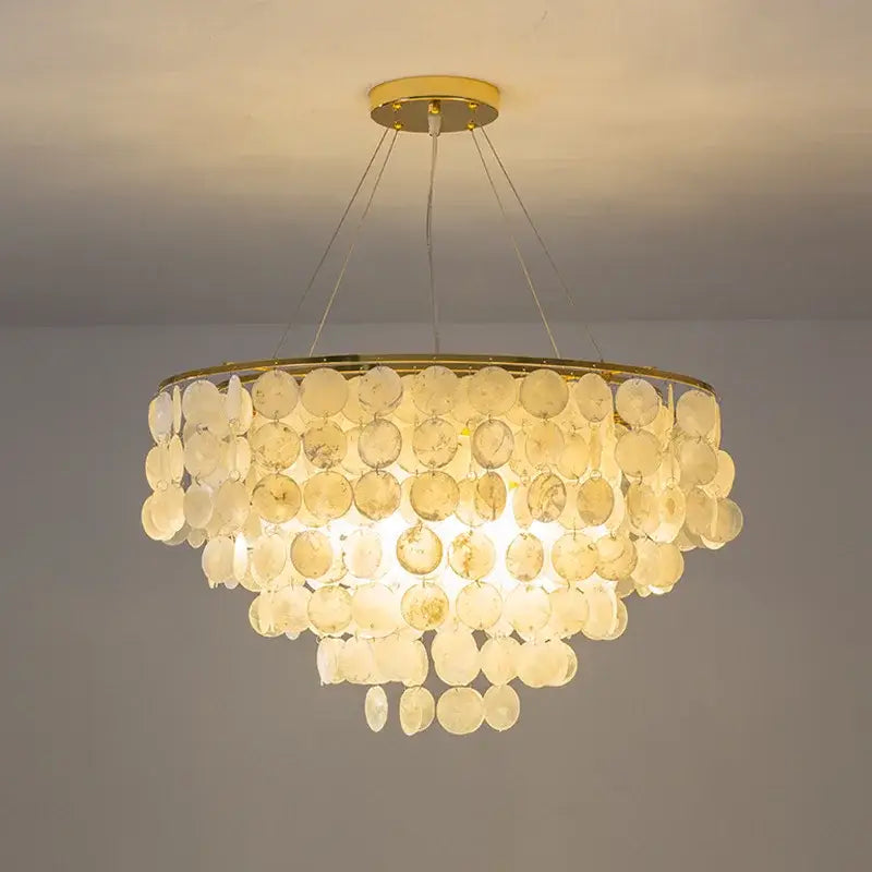 A decorbites led shell chandelier with cascading translucent circular shell discs and a gold chrome metal frame ceiling light