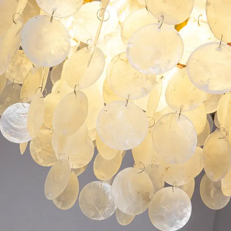 DecorBites led shell chandelier featuring cascading cream seashell discs with modern gold chrome ceiling frame