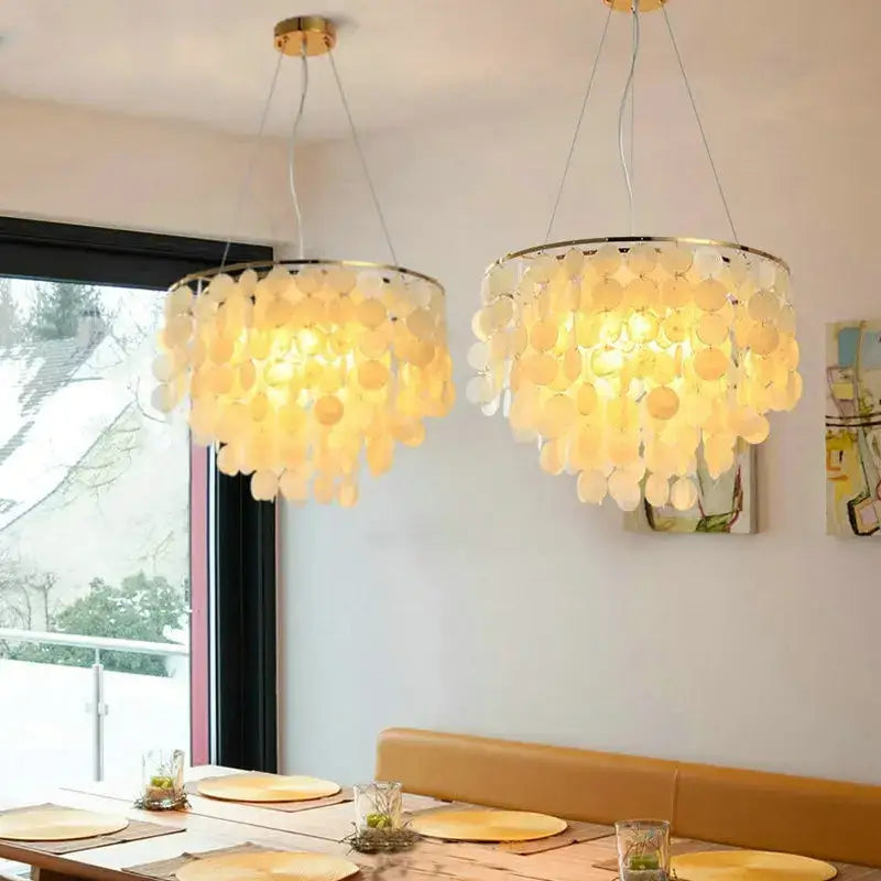 Two elegant warm-toned decorbites led shell chandeliers with cascading translucent shell discs and gold chrome finish