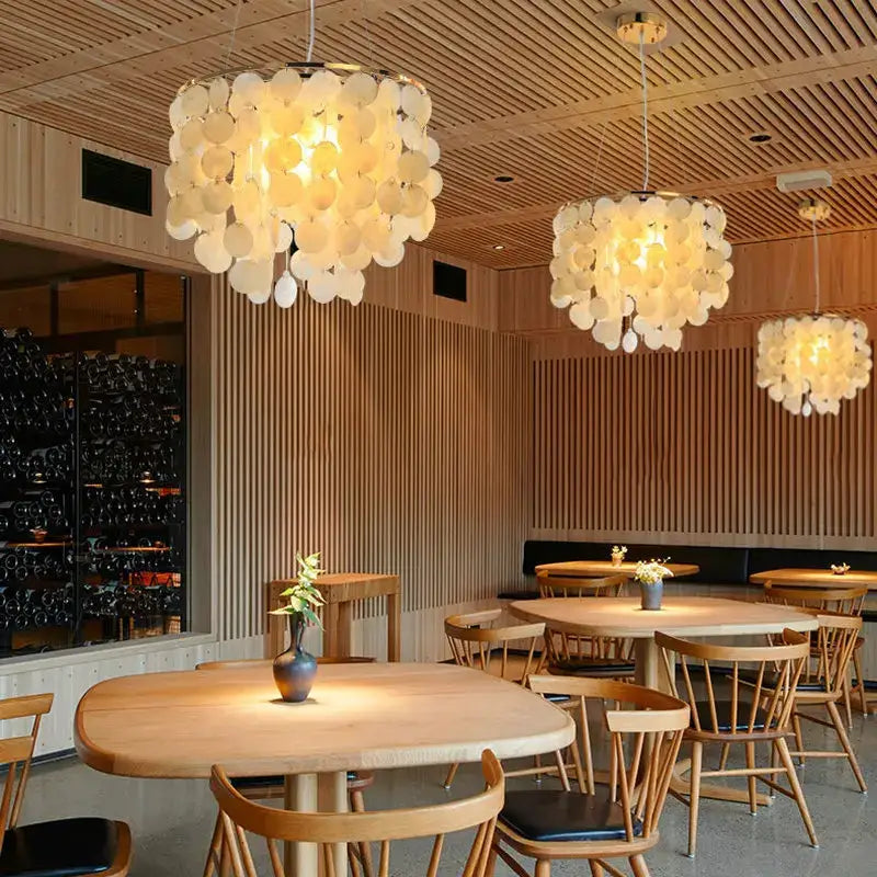 Three elegant off-white DecorBites LED shell pendant lights with petal design in modern gold chrome chandelier