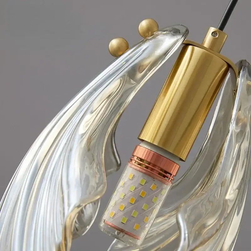 Modern pendant light with clear sculpted glass arms and gold-toned metal accents featuring decorbites led shell bulb