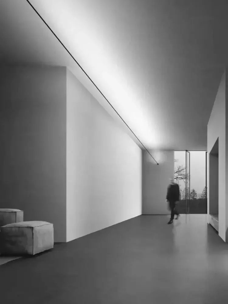Minimalist black-and-white interior hallway featuring decorbites led skyline ceiling wall lamp and modern cube seating