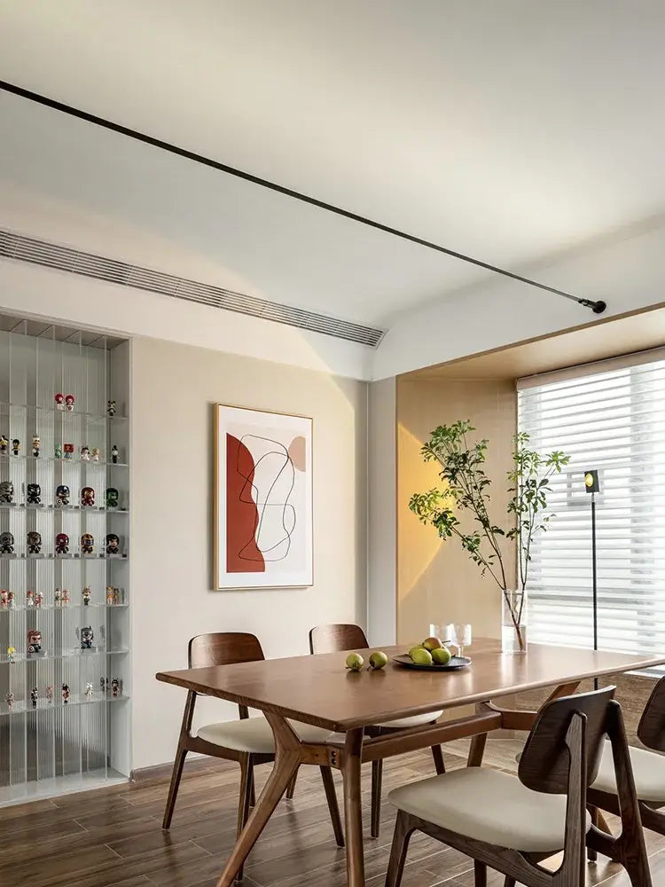 Wooden dining table with smooth warm-toned finish complements decorbites led skyline ceiling wall lamp for modern lighting