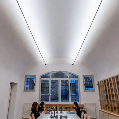 A modern conference room featuring decorbites led skyline steel pendant lights with minimalist linear design