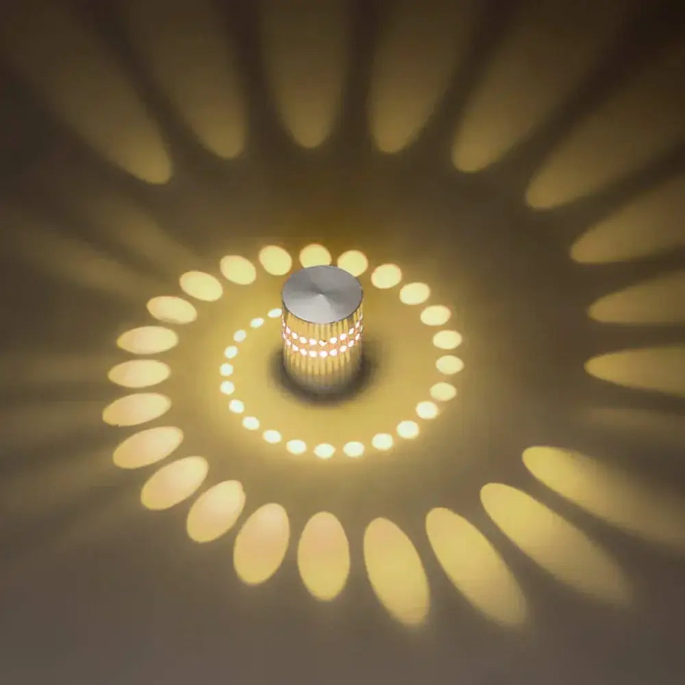 Decorbites led spiral wall light sleek cylindrical brushed metallic finish with warm yellow radial light patterns