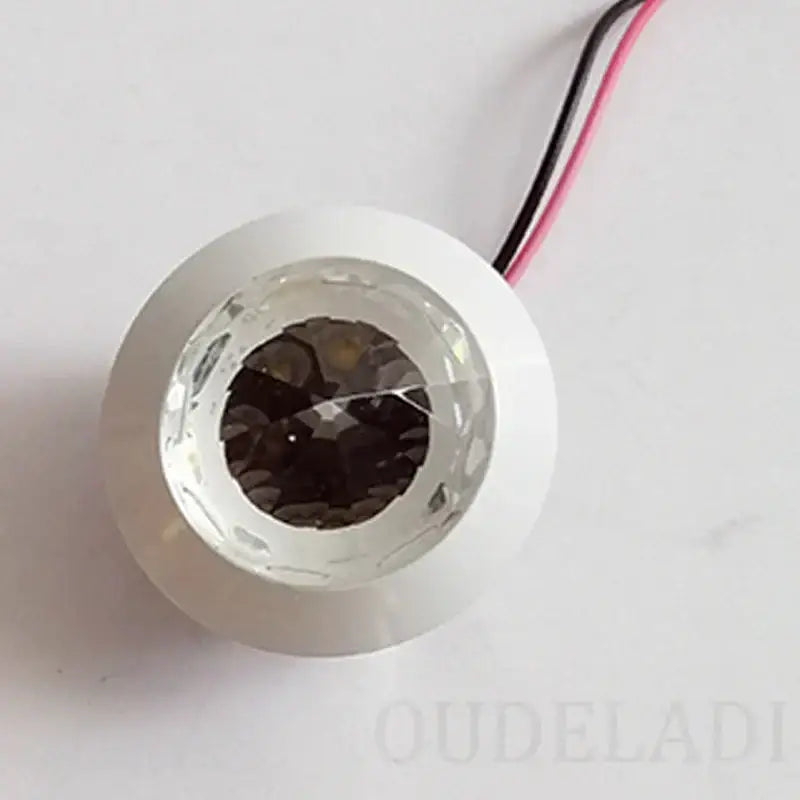 White circular DecorBites LED spot light with faceted crystal lens and visible internal LEDs for home and jewelry cabinet