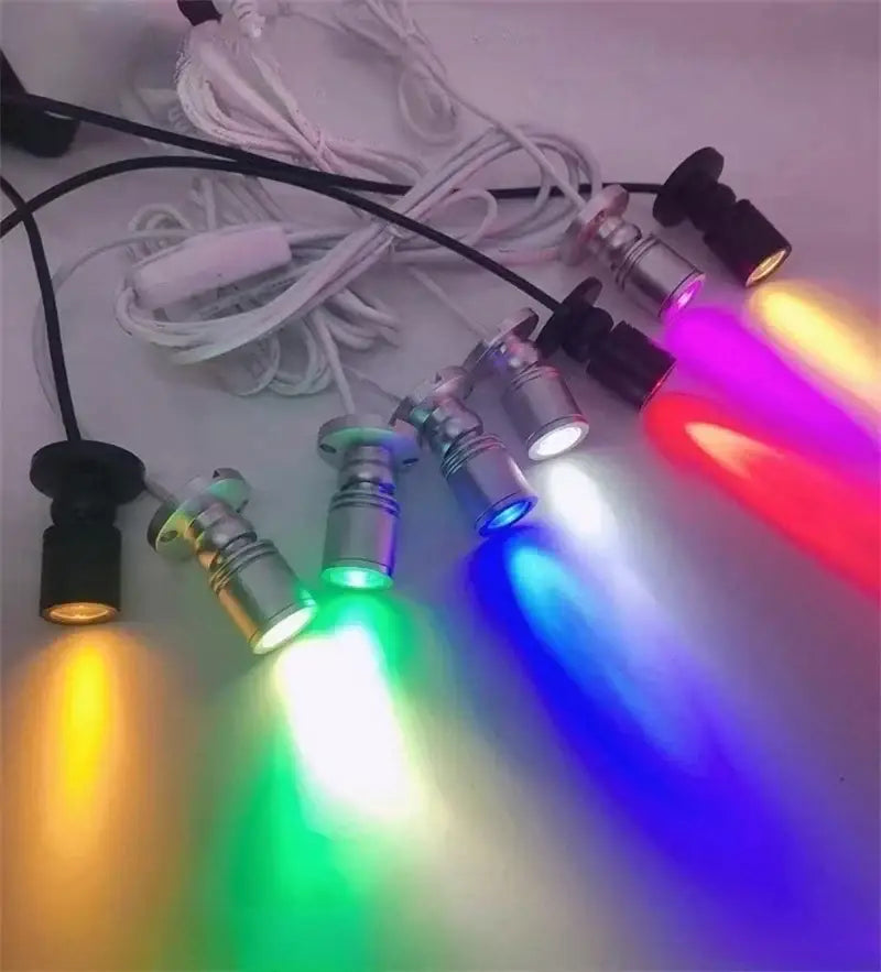 Decorbites led spotlight bulbs with metallic finishes and black bases emitting multicolor light for cabinets and shelves