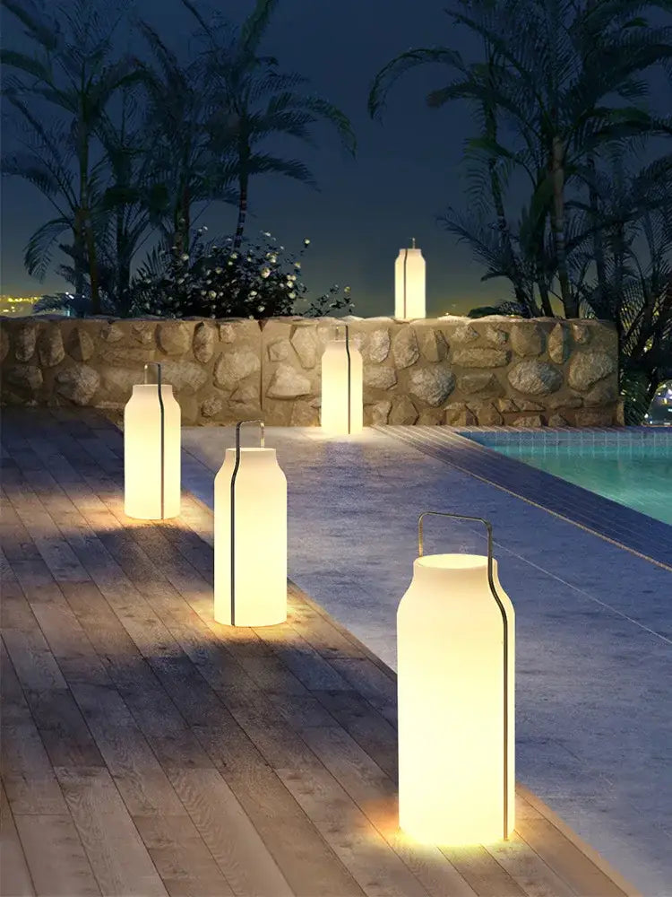 Warm softly glowing white decorbites led stainless steel lawn light with black accents and minimalist metal handles