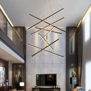 Modern geometric DecorBites™ LED stair ceiling chandelier with black and gold linear bars suspended by thin cables