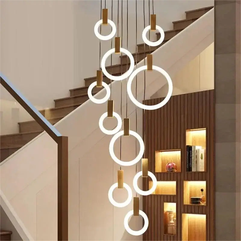 Modern circular decorbites led stair chandelier with warm white led glow and brass-colored metal accents hanging in cascade