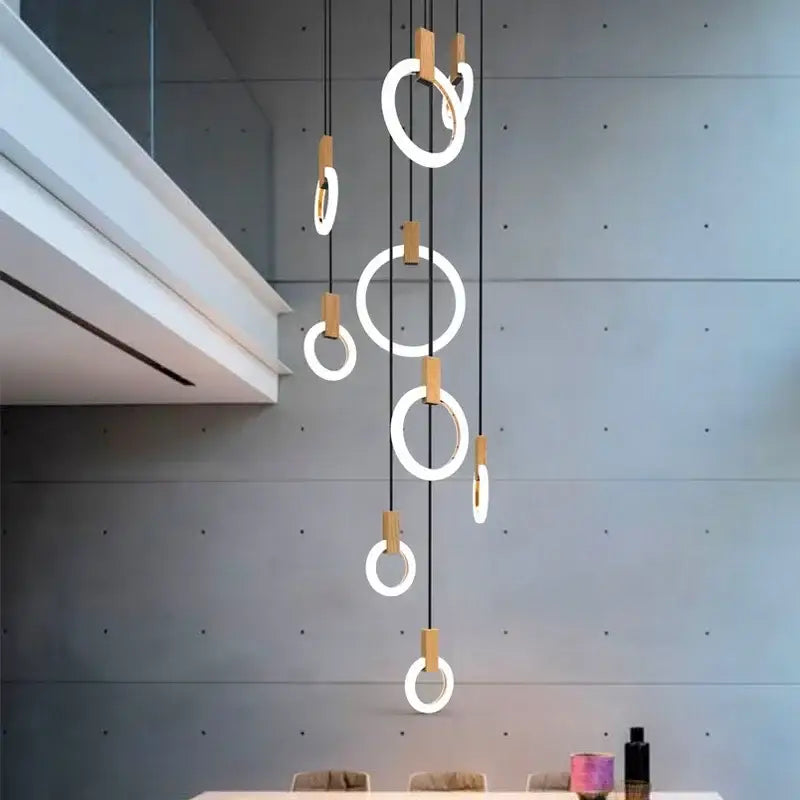 Modern minimalist decorbites led stair chandelier with glowing circular rings, black cords, and wooden accents for ceilings
