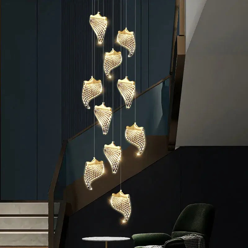 Golden shell-shaped decorbites led staircase chandelier with intricate mesh detailing and warm glowing lights for modern loft lighting