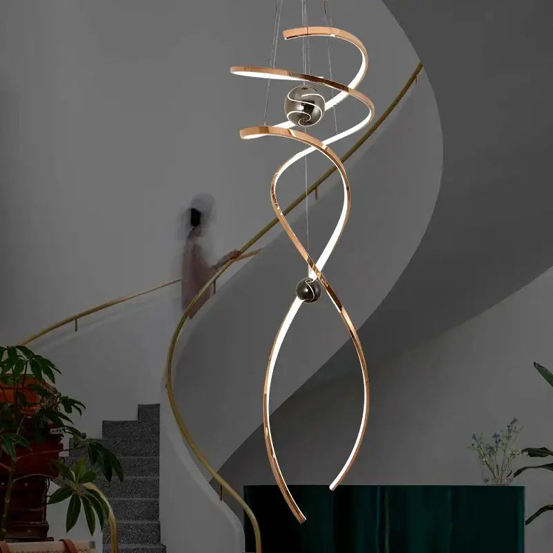 A modern decorbites led staircase pendant light with brushed gold finish and integrated led lighting for indoor use