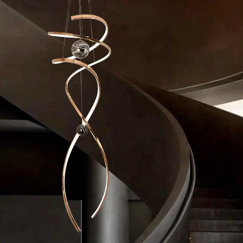 A modern decorbites led staircase pendant light with brushed gold finish and two spherical glass accents