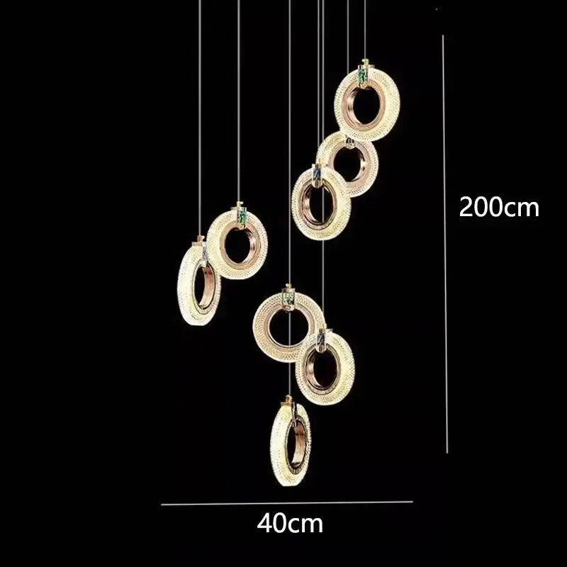 Decorbites led staircase chandelier with gold-toned rings and sparkling crystals featuring green gemstones for indoor lighting