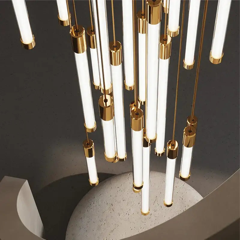 Modern chandelier with slender white glass tubes and gold rods in decorbites led staircase chandeliers for luxury spaces