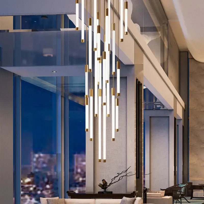 Modern minimalist led staircase chandeliers with white cylindrical tubes and gold accents for luxury living spaces