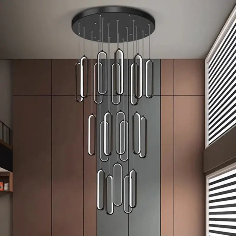 Modern black circular DecorBites LED staircase chandelier with sleek elongated oval pendant lights for living room decor