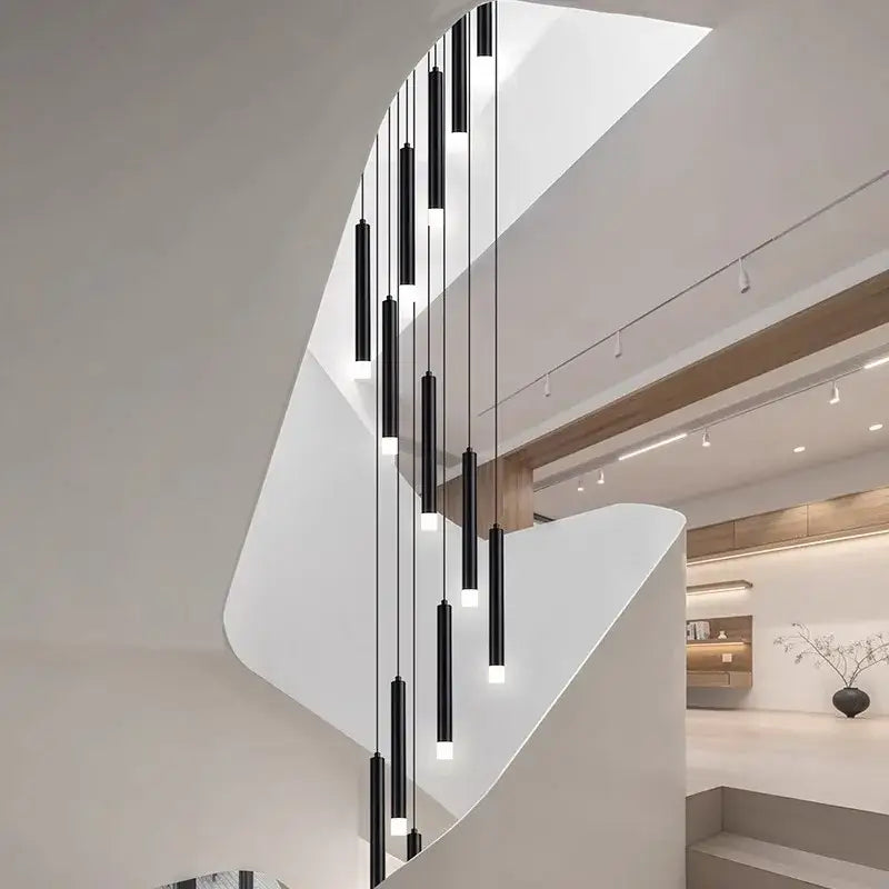 A modern black cylindrical decorbites led staircase pendant light fixture with sleek minimalist design for living room decor