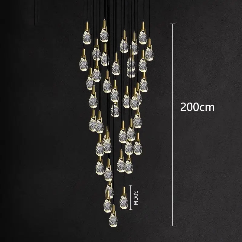 A modern DecorBites led staircase pendant light with clear glass teardrop pendants and brass fittings measuring 200cm tall