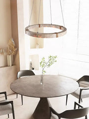 Circular pendant light featuring a textured metallic stone ring with warm lighting by DecorBites led stone ring chandelier