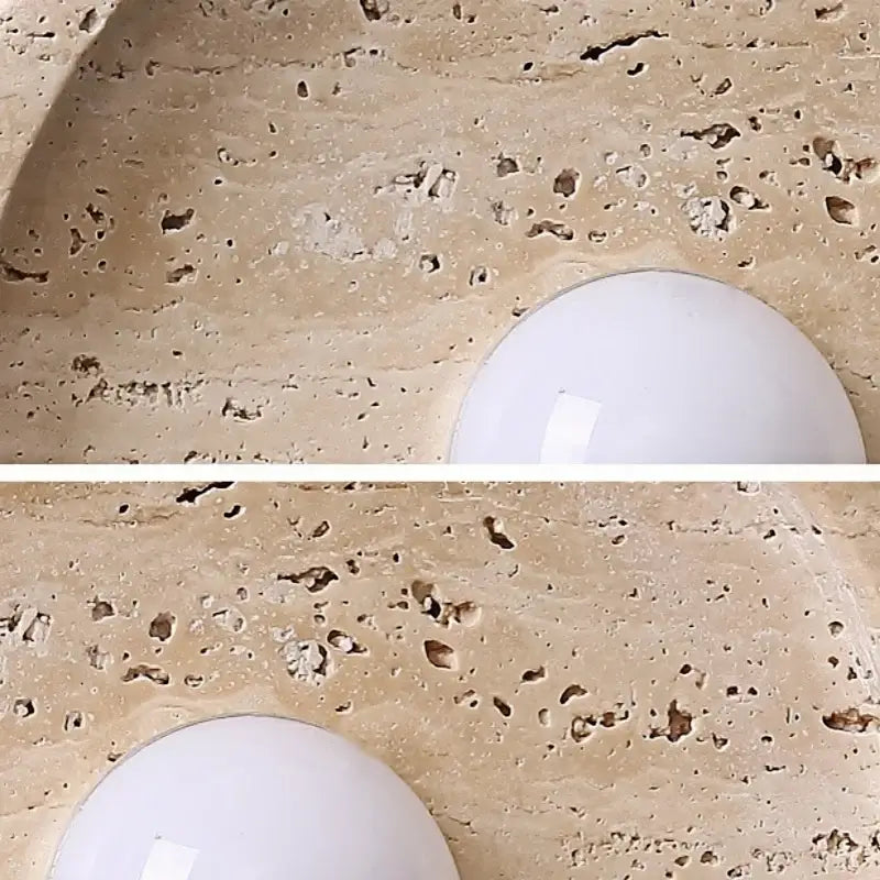 A white round DecorBites led stone wall lamp mounted on a textured beige stone countertop for home decor