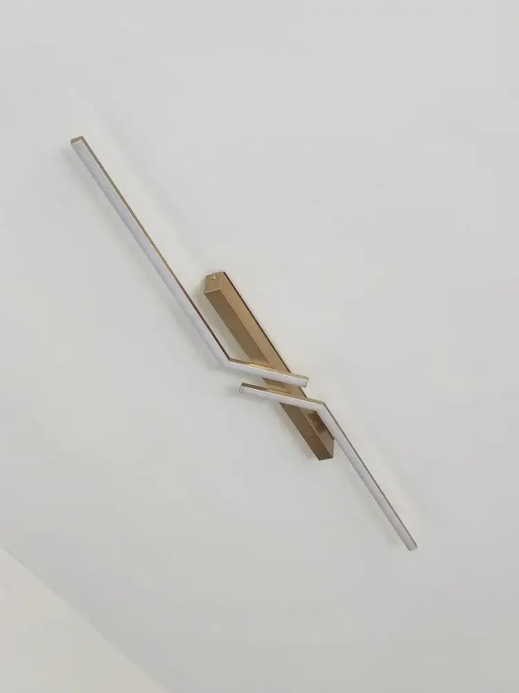 Modern minimalist wall sconce with sleek silver and gold-toned metal arms for decorbites led strip ceiling lights