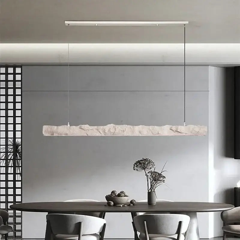 A modern minimalist pendant light with textured off-white stone finish and white metal frame in decorbites led strip chandelier