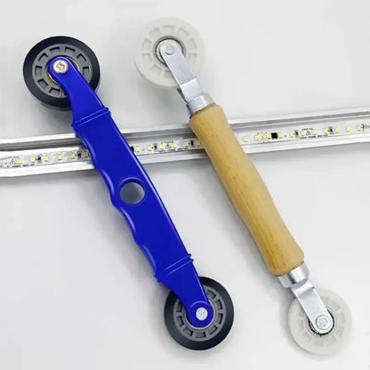 Decorbites™ led strip light installation tool with blue wooden handle and black white rubber wheels for smooth guiding