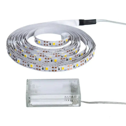 Coiled white decorbites™ led strip light smd2835 with yellow leds and a clear plastic battery pack flexible ribbon tape