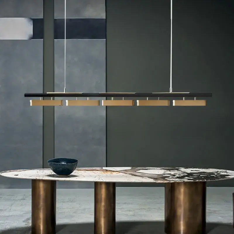 DecorBites™ modern minimalist strip pendant lights feature a sleek black bar with five gold-toned minimalist strip LED fixtures