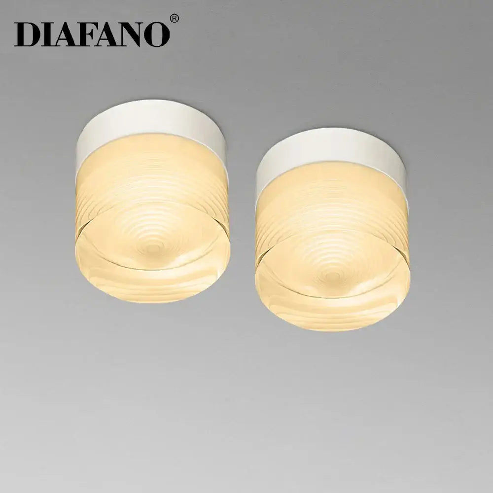 Two white diafano decorbites led surface mounted spot lights with textured amber glass shades for ceiling use