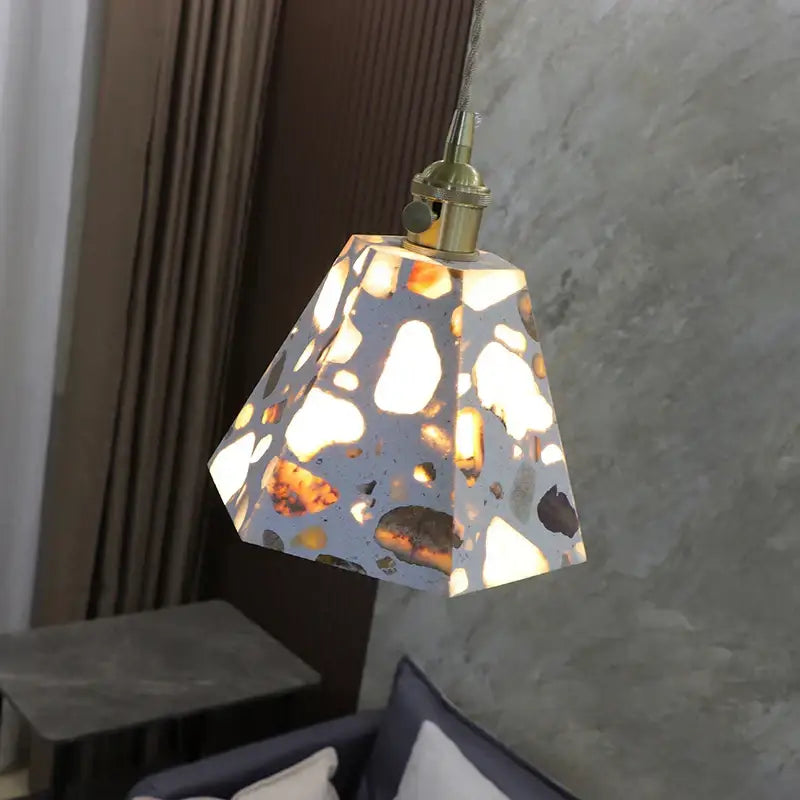 A decorbites led terrazzo geometric pendant light with speckled concrete finish and brass fixture for living rooms