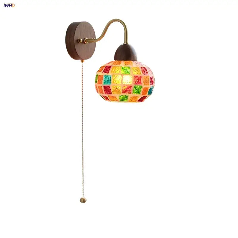 A decorbites led tiffany style wall sconce with colorful mosaic glass tiles, brass arm, and wooden backplate