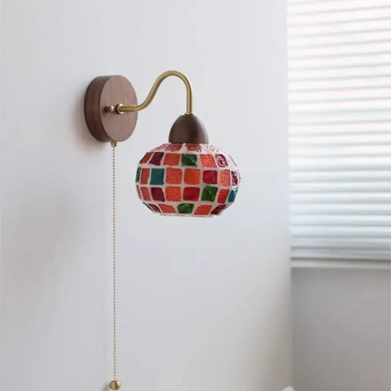 A colorful mosaic glass DecorBites LED Tiffany style wall sconce with brass arm and wooden backplate for stairs