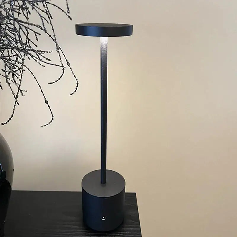 Black cylindrical DecorBites LED touch dimming table lamp with sleek minimalist design and glowing light for reading