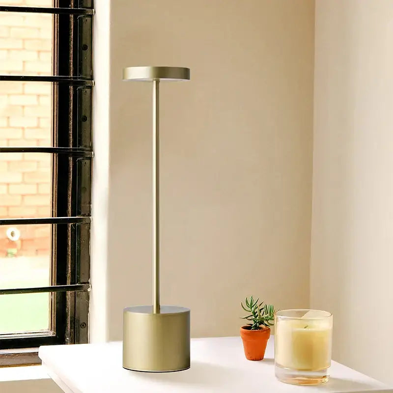 Modern minimalist DecorBites LED touch dimming table lamp with gold metal body and slender stem for living room use