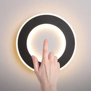 Modern circular wall light decorbites led touch switch with sleek black and white design and warm ambient glow