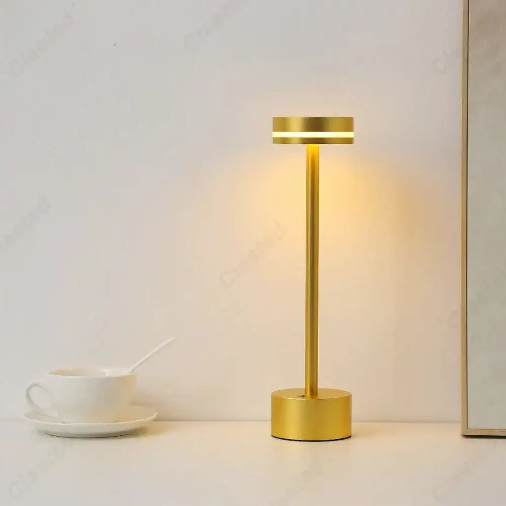 Gold-colored DecorBites LED touch table lamp with sleek cylindrical design and warm ambient rechargeable lighting for living room