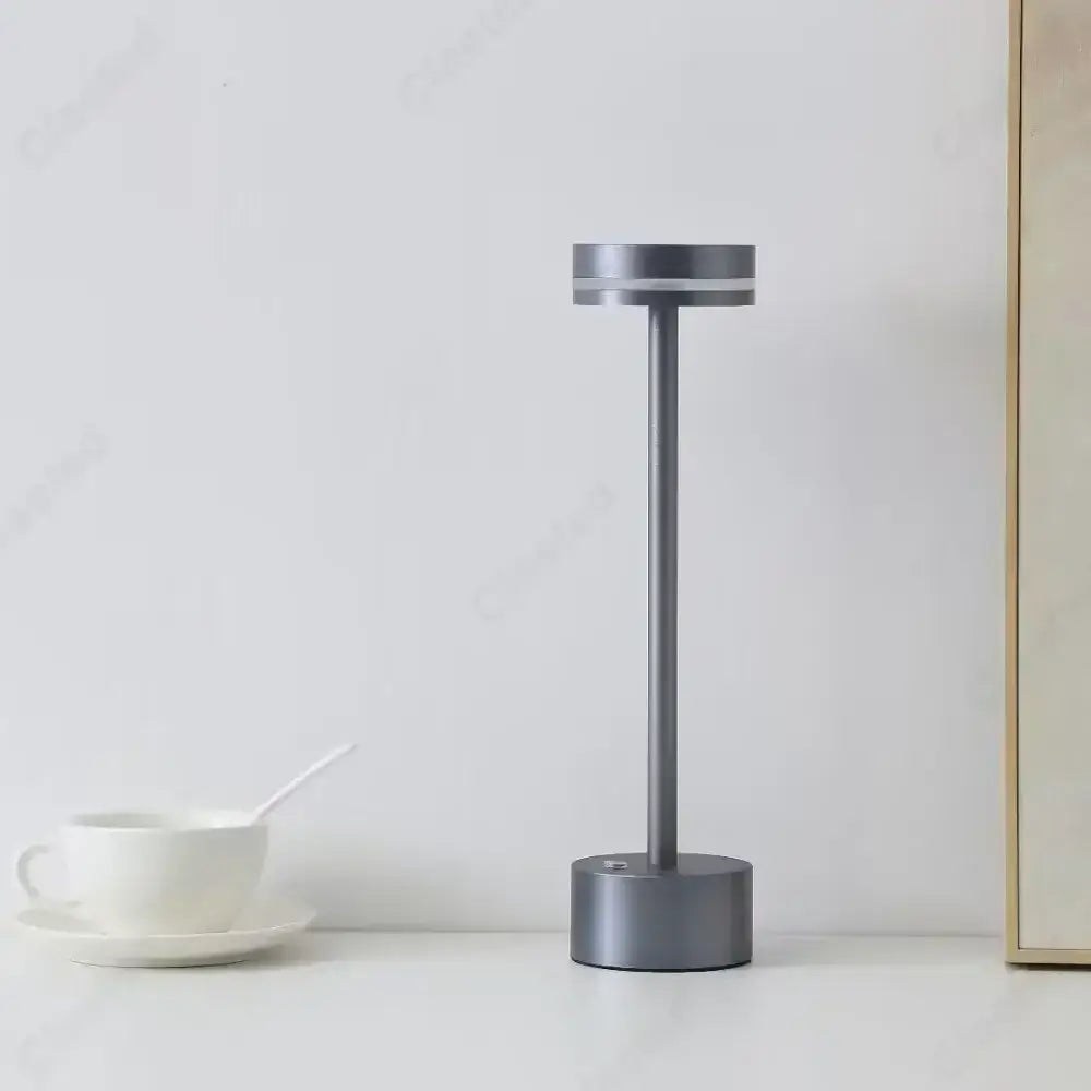 Modern minimalist gray metallic decorbites led touch table lamp with cylindrical body and circular base for living room use